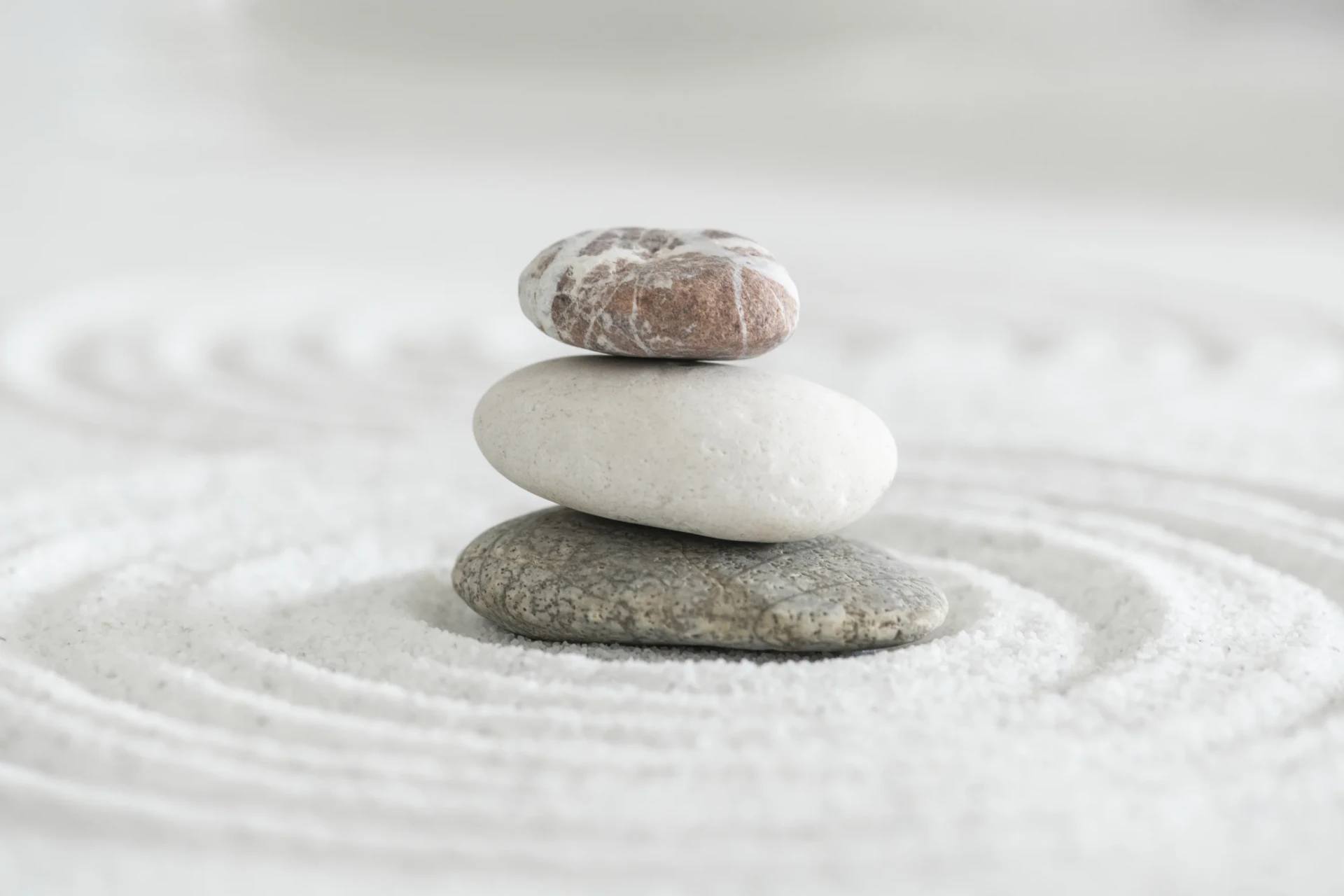Piedras zen apiladas en equilibrio, simbolizando la calma y el retorno al centro que encontrarás en Sintonía Cero